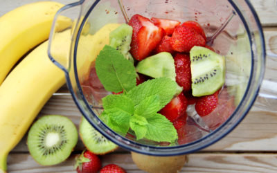 Kiwis, strawberries and mints in a blender ready to be made into a smoothie