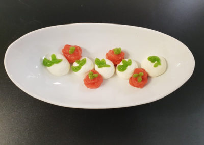 Piped Caprese salad, featuring mozzarella pearls, cherry tomato, basil and virgin olive oil